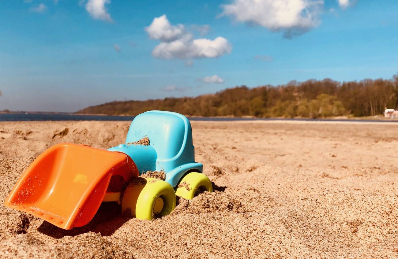 Spielzeugbagger im Sand am Elbufer